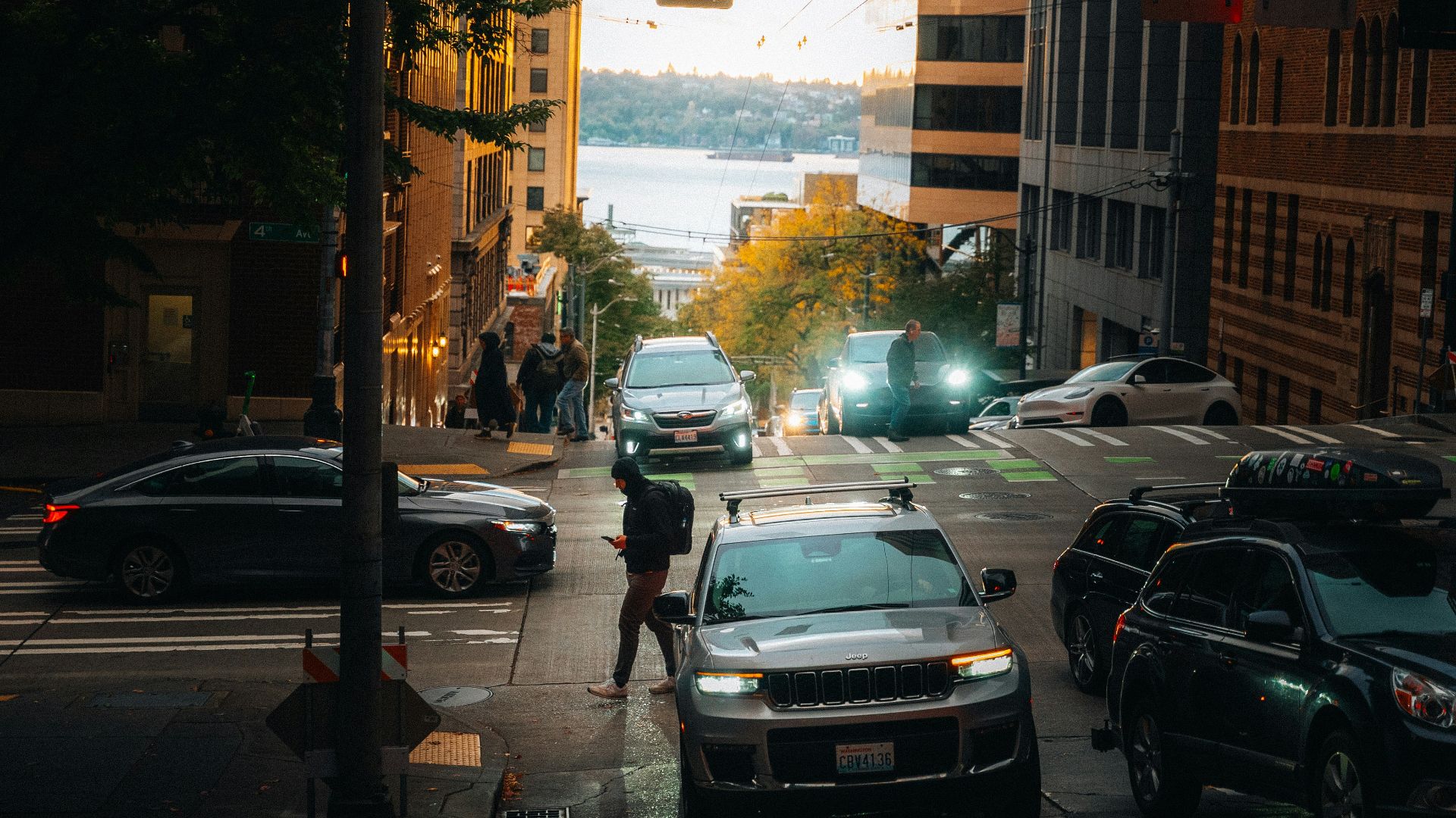City street with cars and pedestrians at dusk