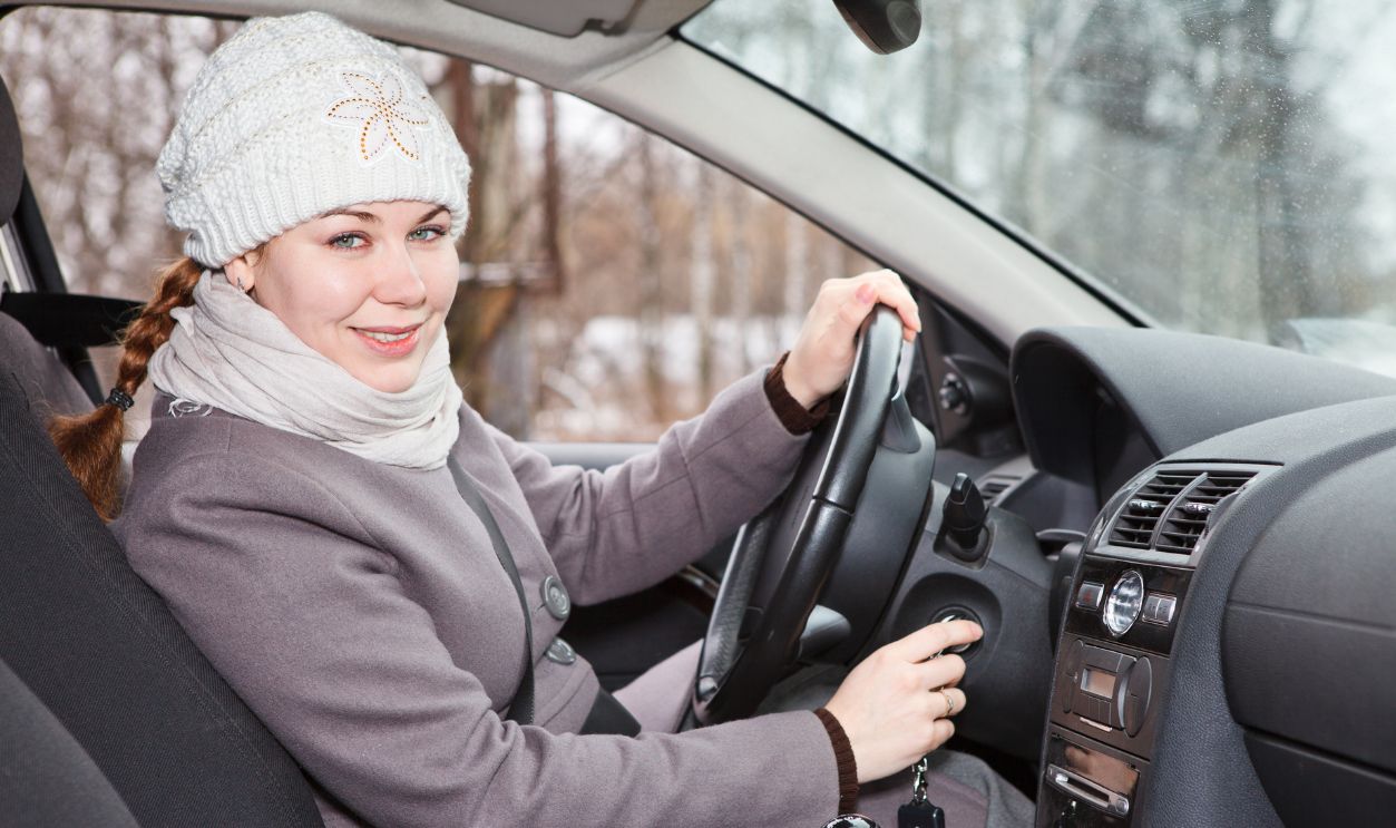 Female driver putting ignition key and starting car