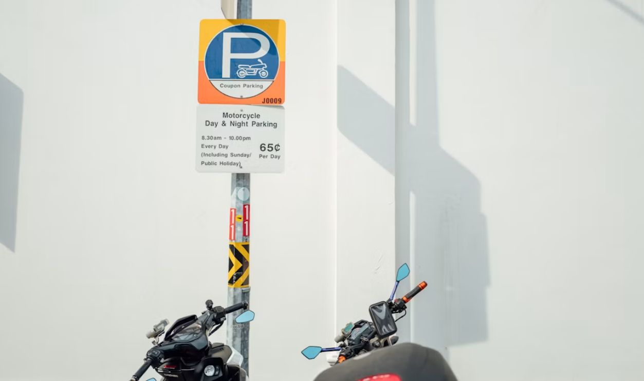 a motorcycle parked next to a parking sign
