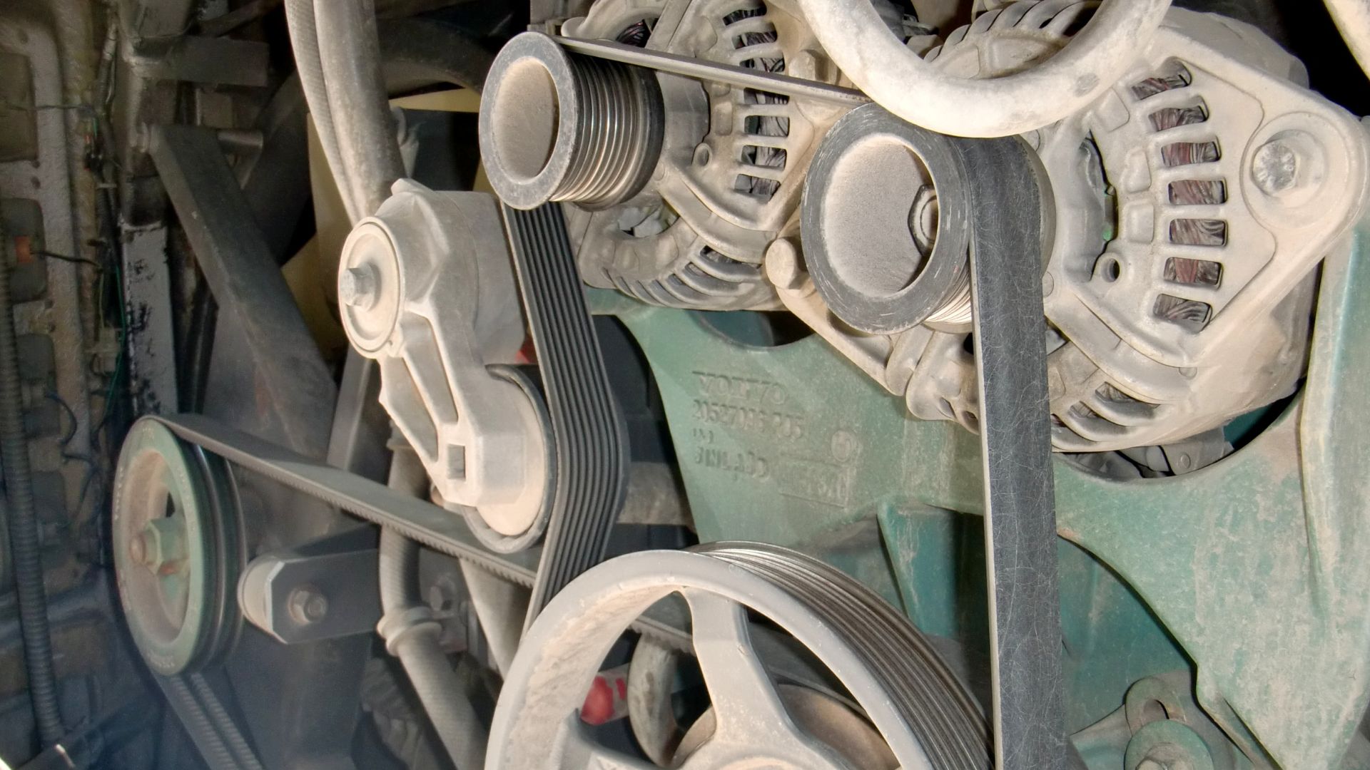 Belt drive system of VOLVO bus engine room. V-rib-belt(near) & Timing belt