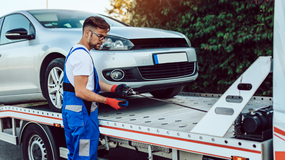 Handsome middle age man working in towing service on the road.