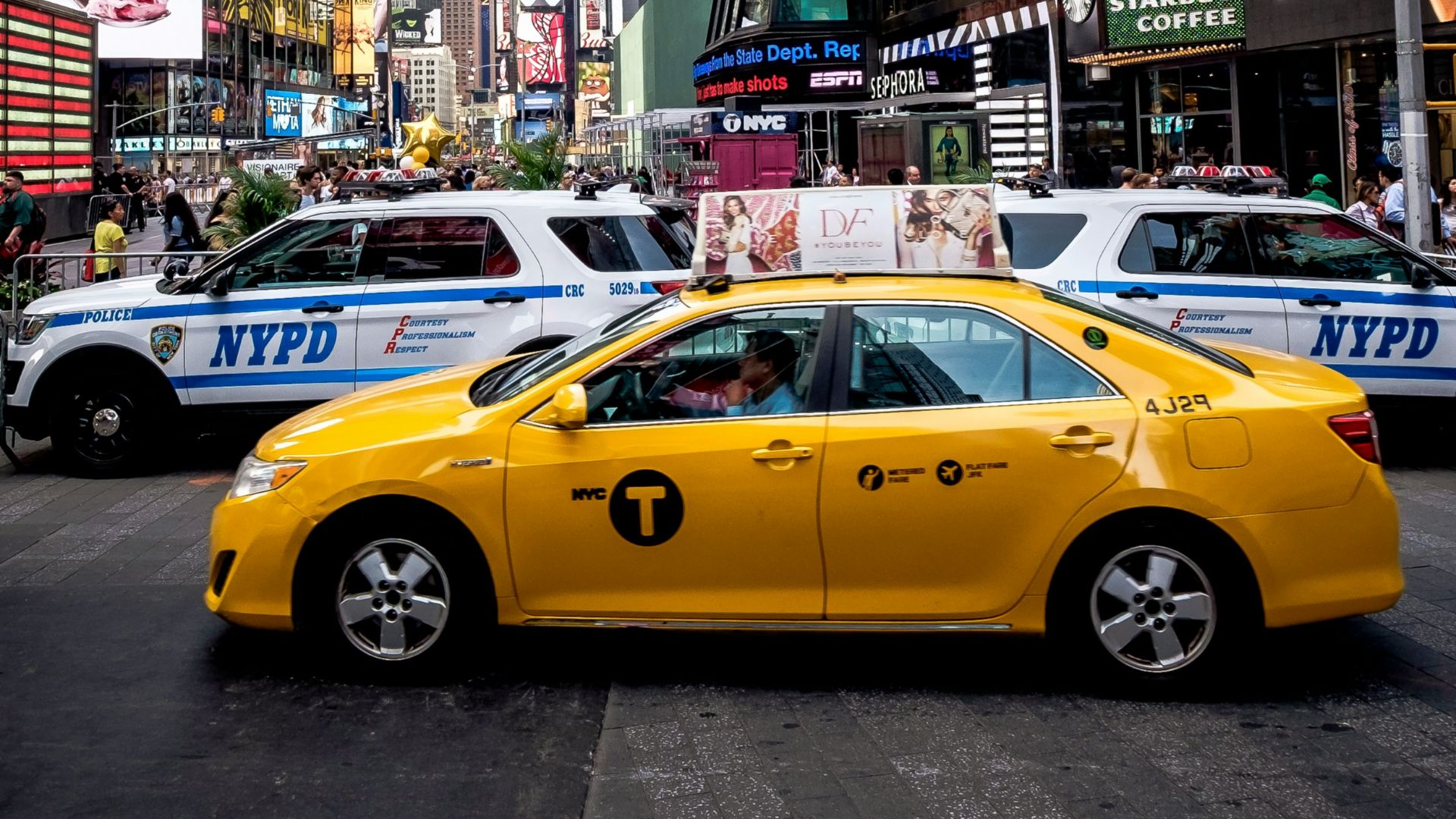 yellow sedan beside police cars