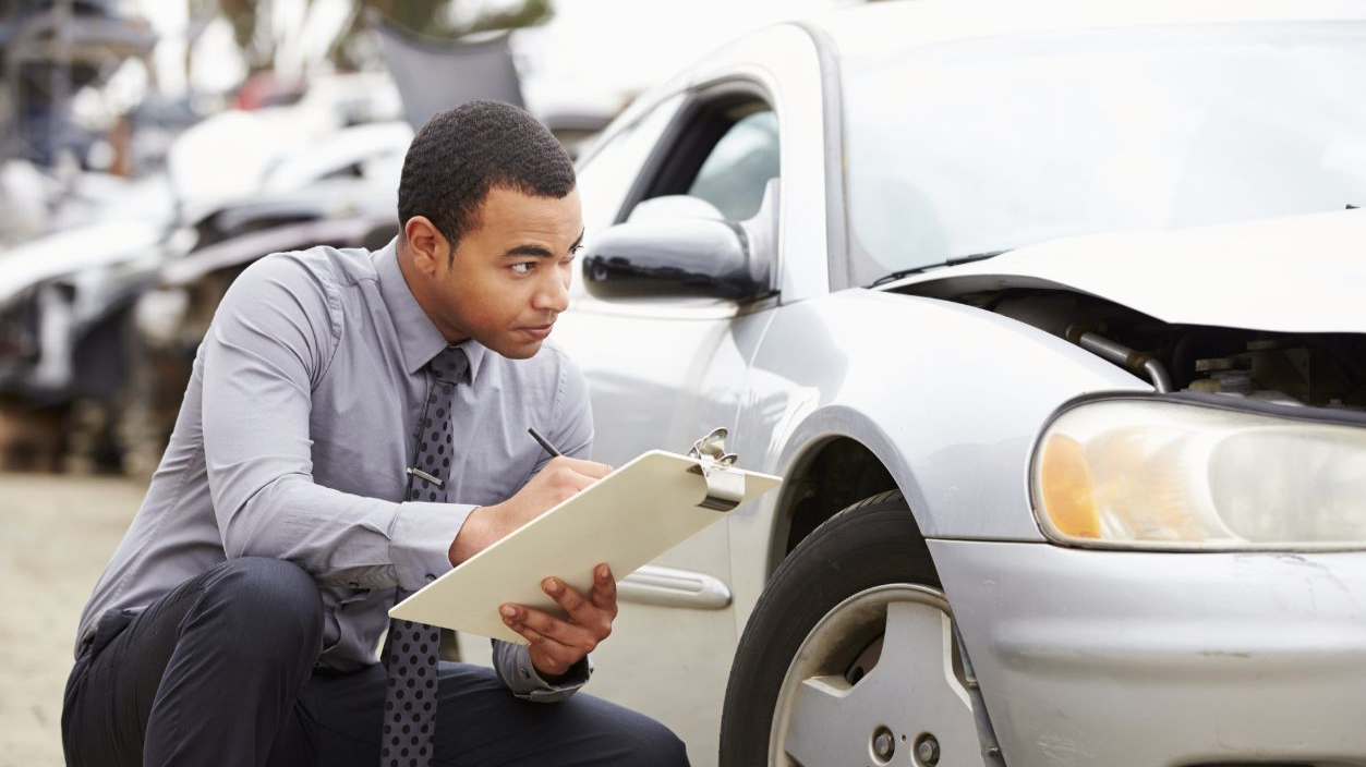 Loss Adjuster Inspecting Car Involved In Accident