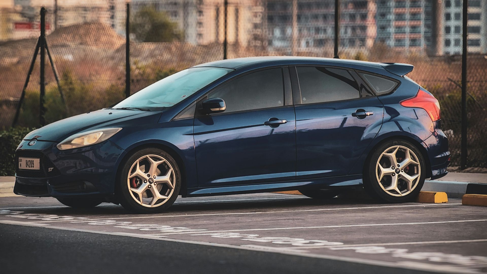 A small blue car parked in a parking lot