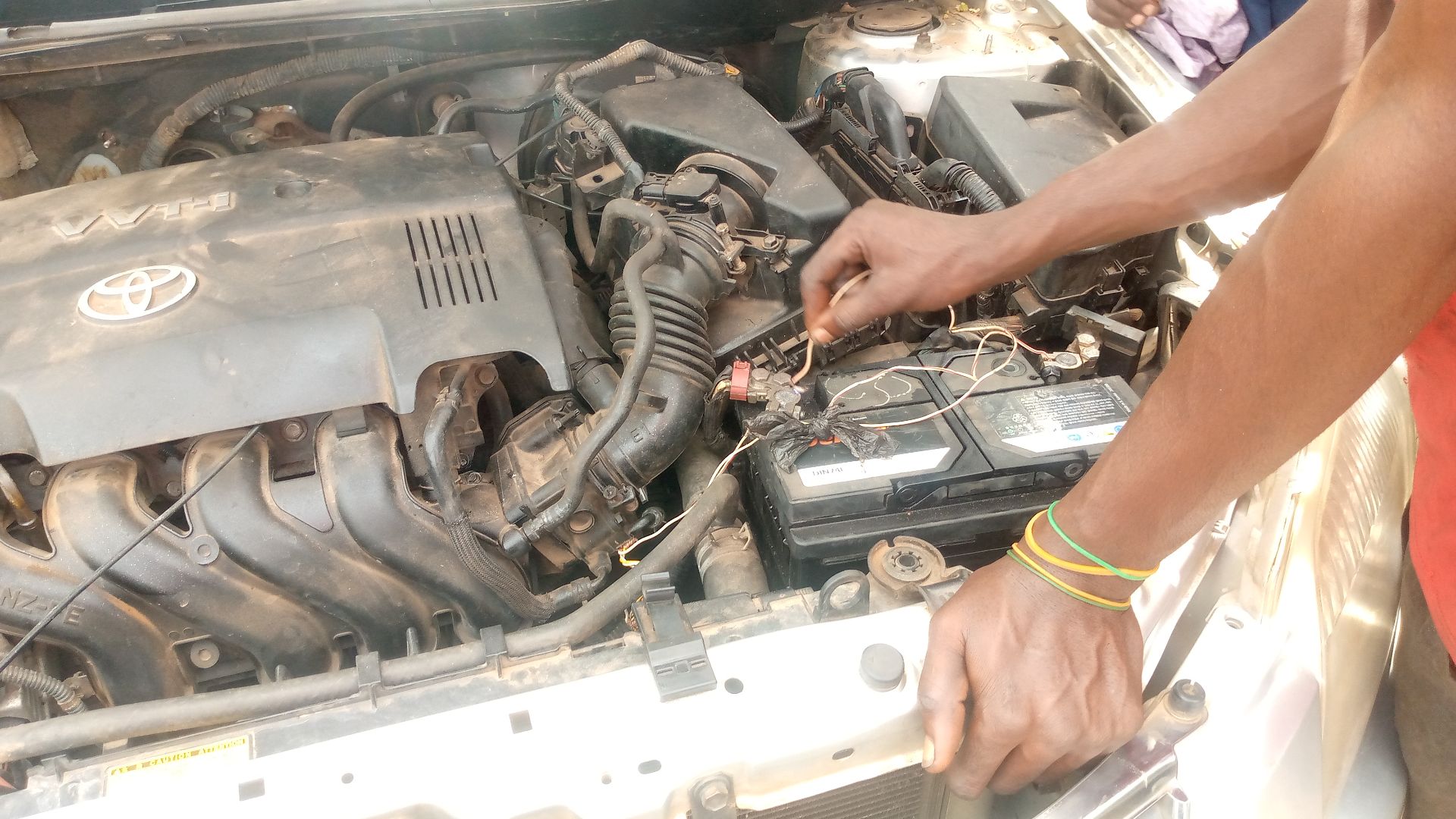 Mechanic checking the car battery for any faults