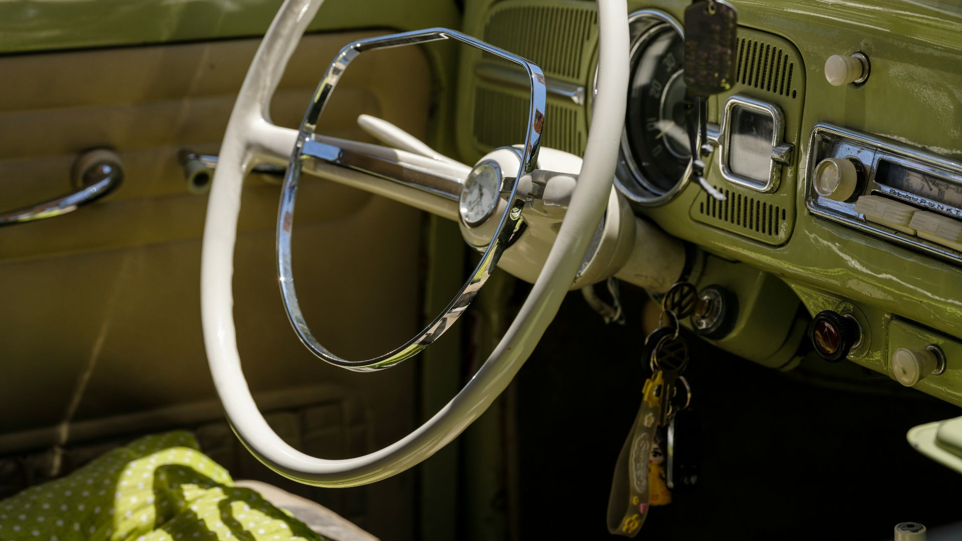 A green car with a steering wheel and dashboard