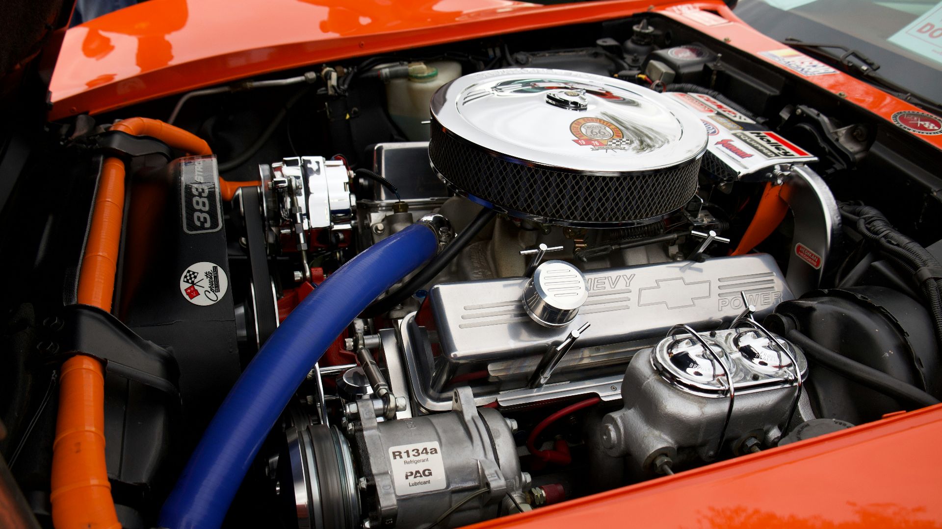 Bright orange car engine with chrome and blue accents