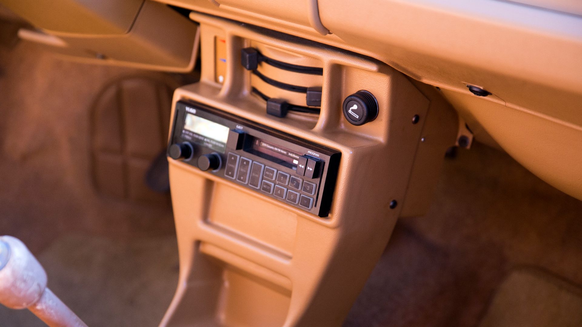 The centre console and Yugo-branded head unit (model 5732) of a Burgundy 1987 Yugo GV at the wheels_of_nyc Cars & Coffee at the Greenpoint Terminal Market, Brooklyn. 1.1-litre engine and four-speed manual transmission. Originally delivered in Iowa, spent 