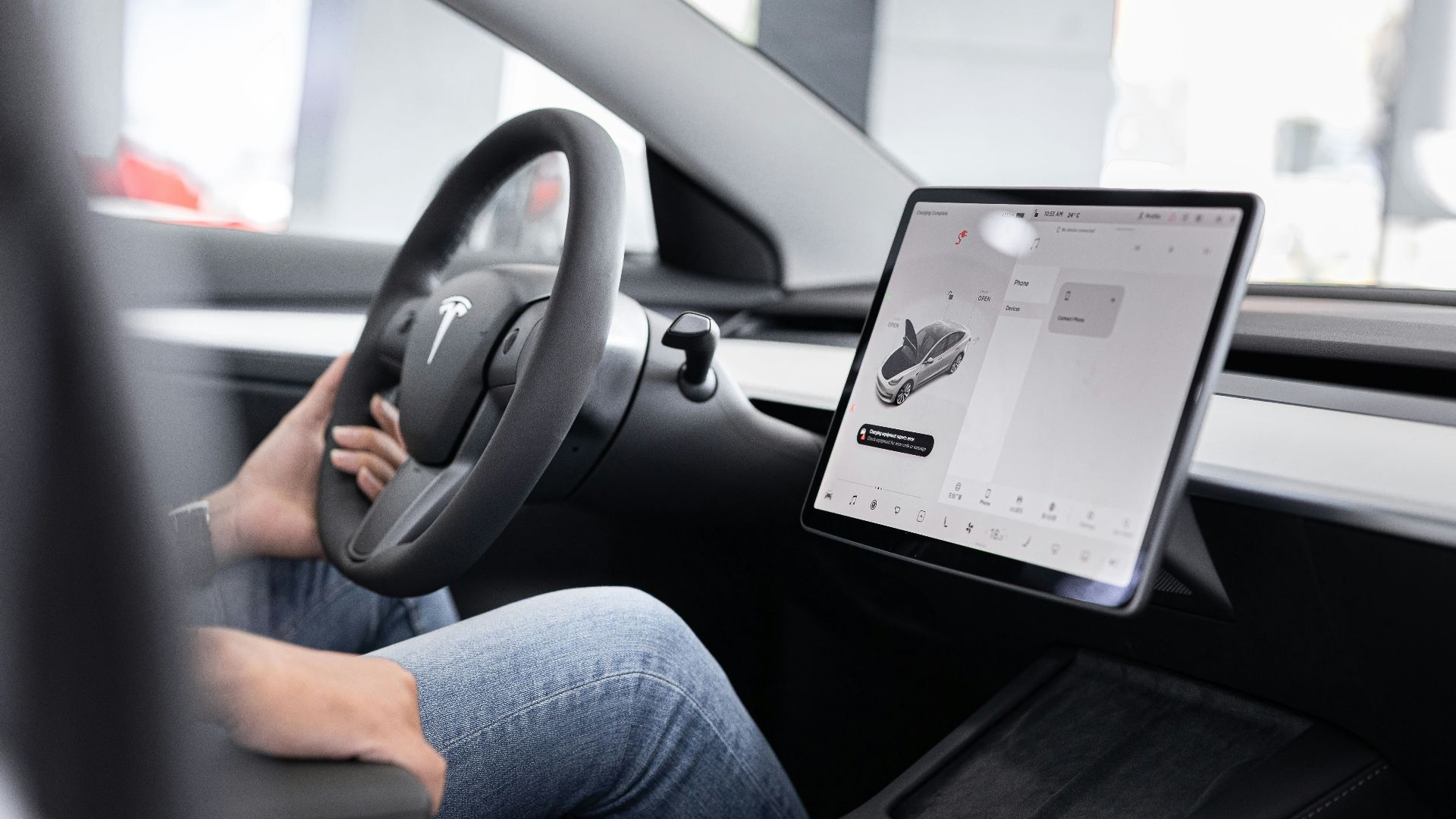 a person sitting in a car with a tablet
