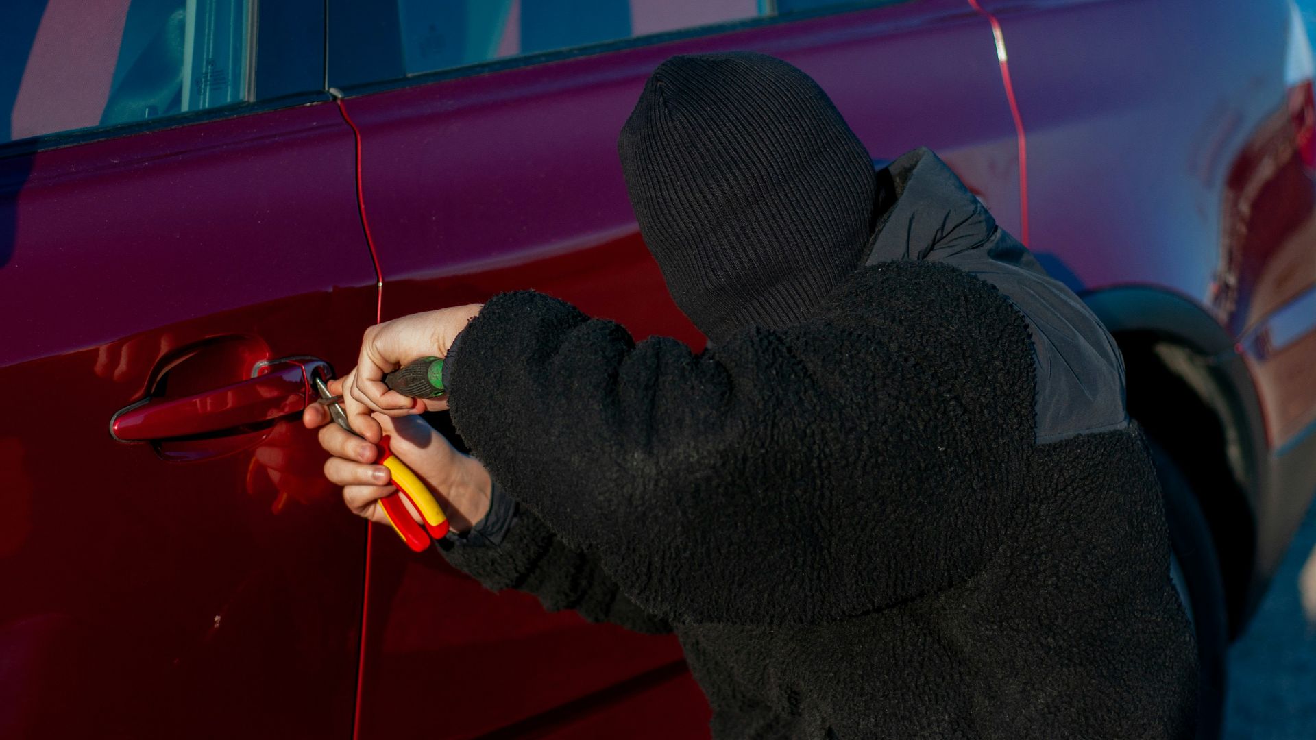 A person is trying to break into a car