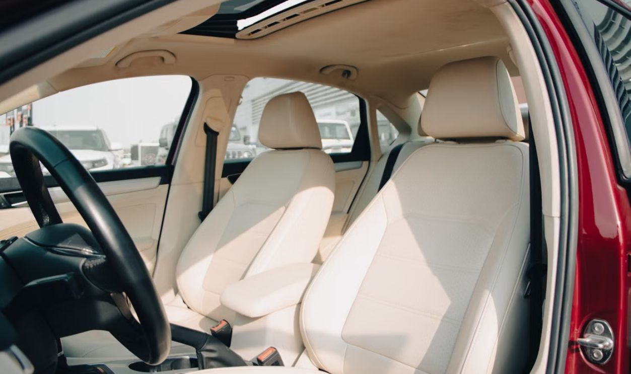 Spacious car interior featuring elegant cream leather seats and modern design elements