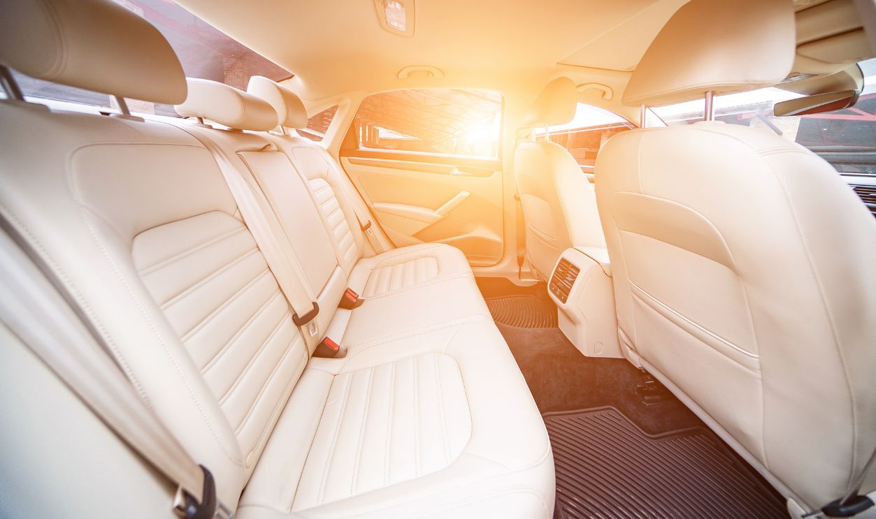 Car interior luxury. Beige comfortable seats, steering wheel, dashboard, climate control, speedometer, display, wood decoration light