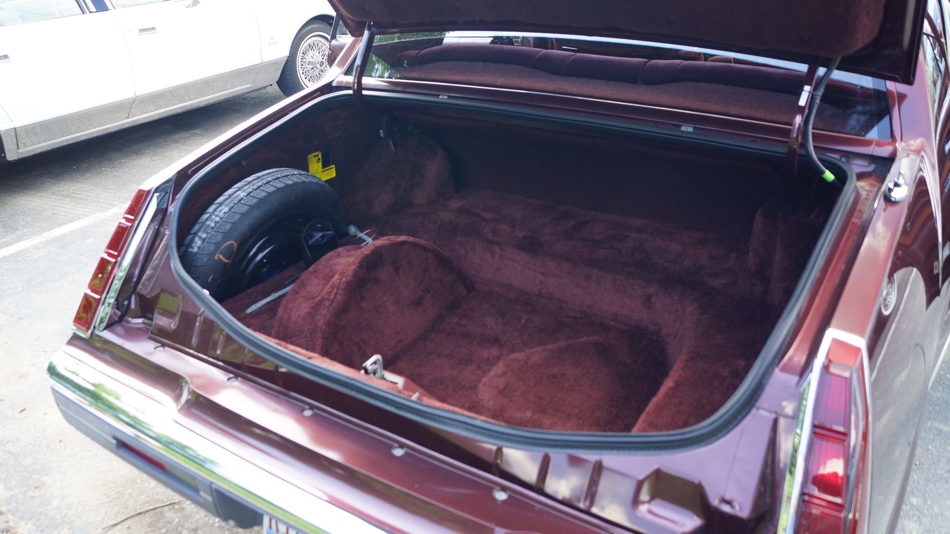 Open trunk of a 1984-1985 Lincoln Continental, showing spare tire placement (compared to styled
