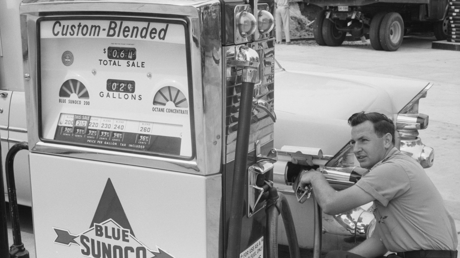 Gas station attendant filling a car tank with custom blend gas, at a Sunoco gas station, Washington, D.C. area