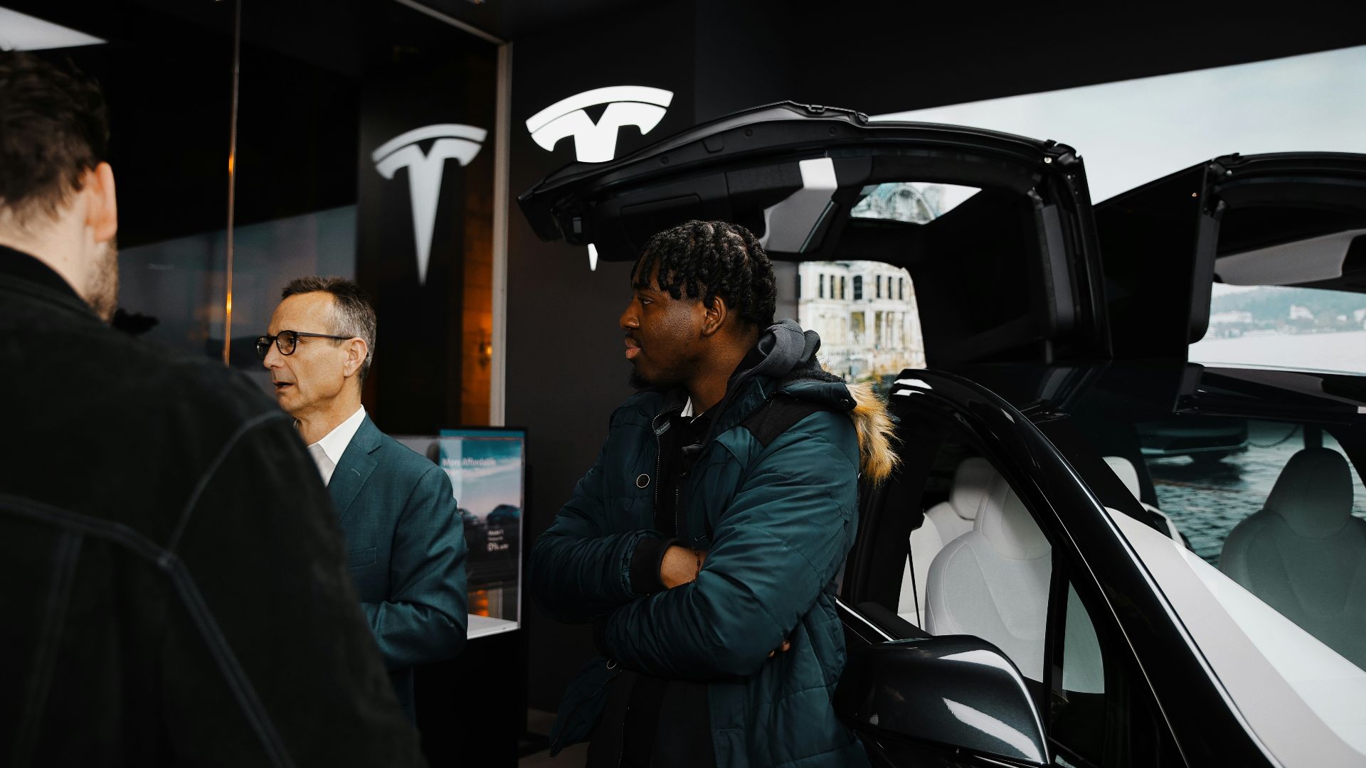 A group of people standing around a car