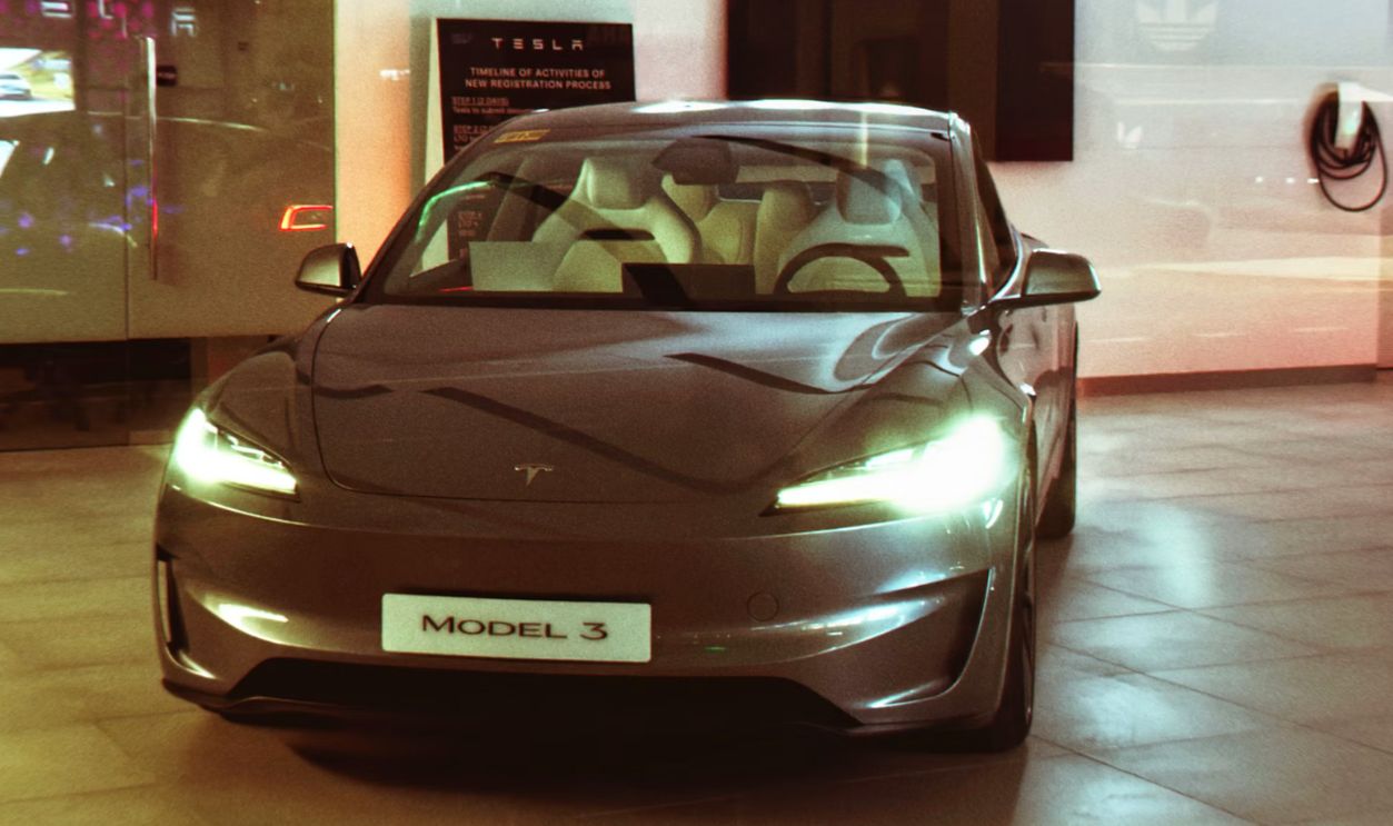 A tesla model 3 is displayed inside a showroom