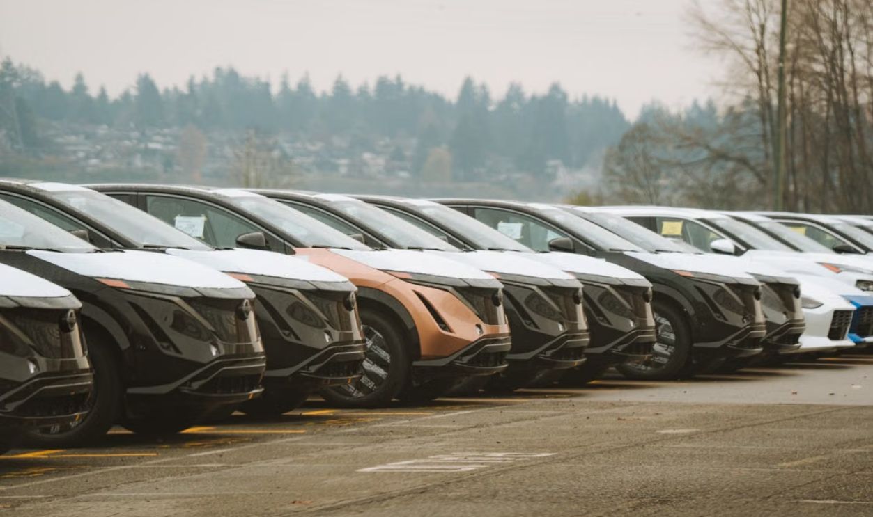 Rows of sleek electric cars parked outdoors, showcasing automotive design and innovation.
