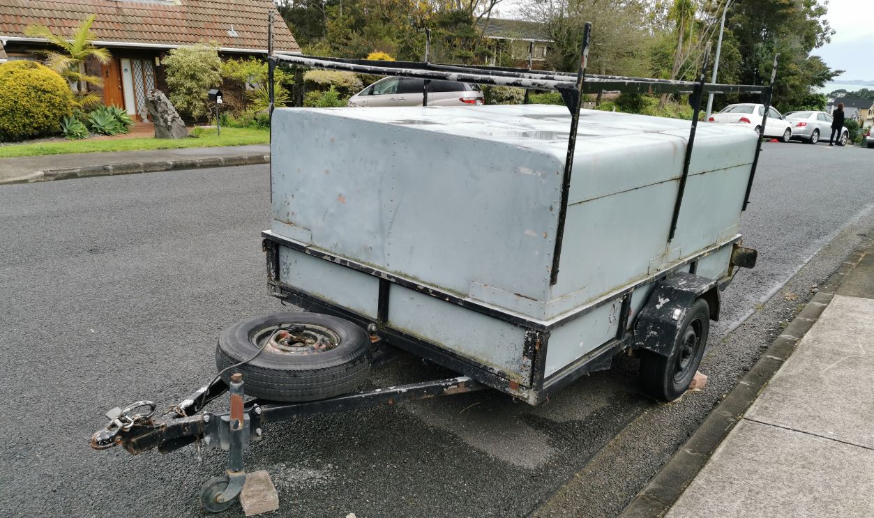 Auckland / New Zealand - September 24 2020: View of small 2-axle box trailer parked in suburban street