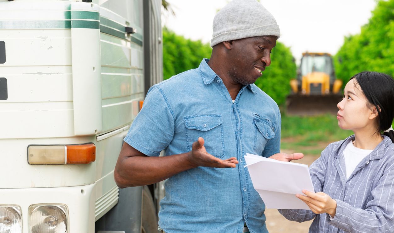 African man and Chinese girl speaking near truck