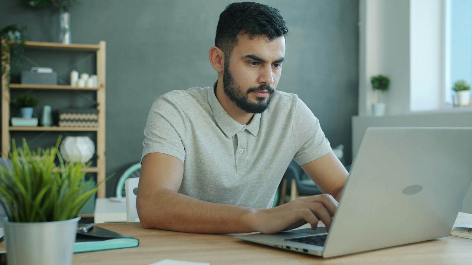Man typing on a laptop at a desk