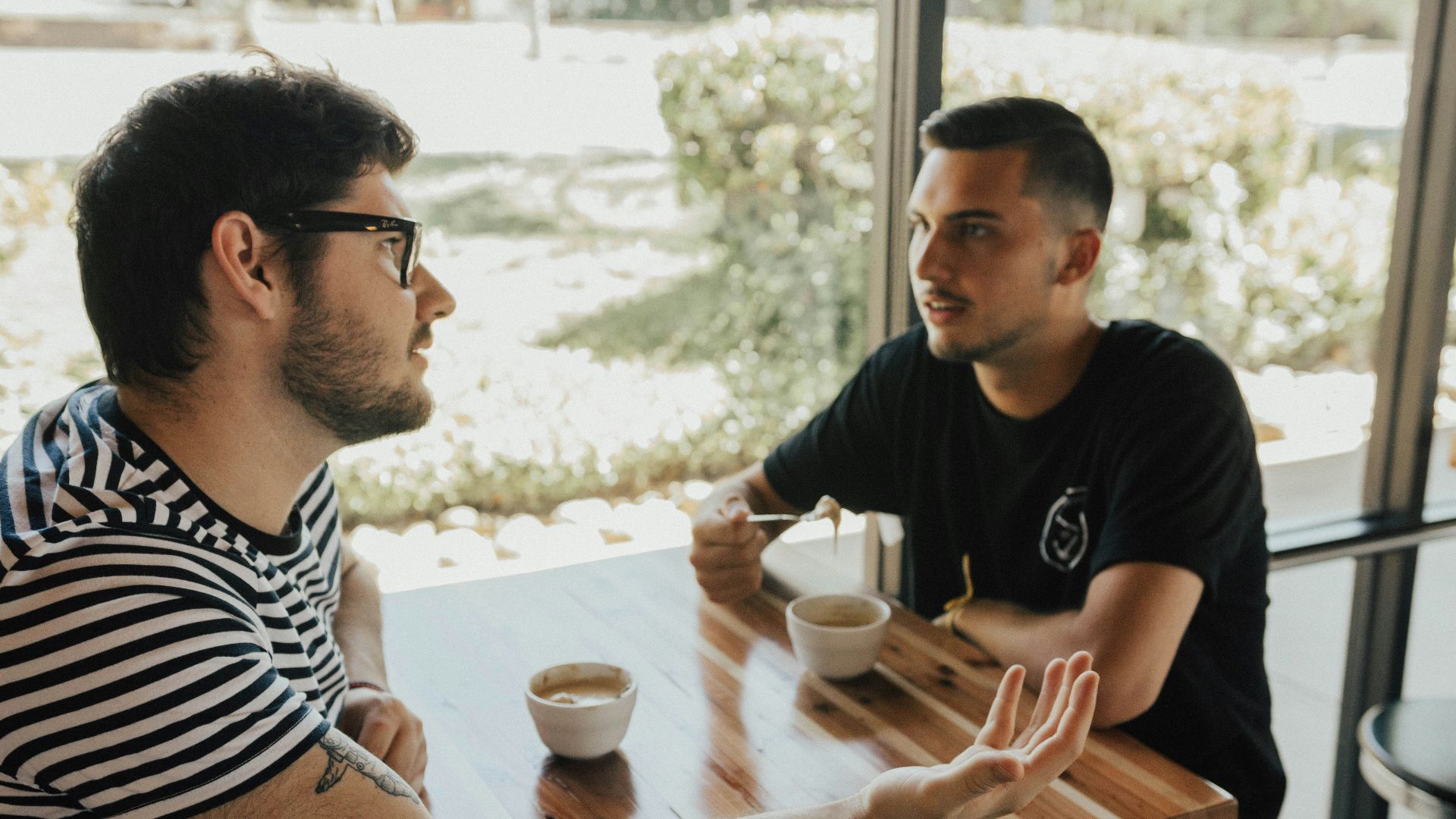 two men having conversation on table
