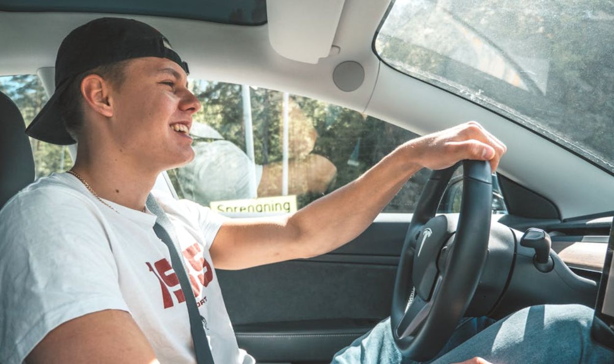 Man in White T-shirt Driving a Car