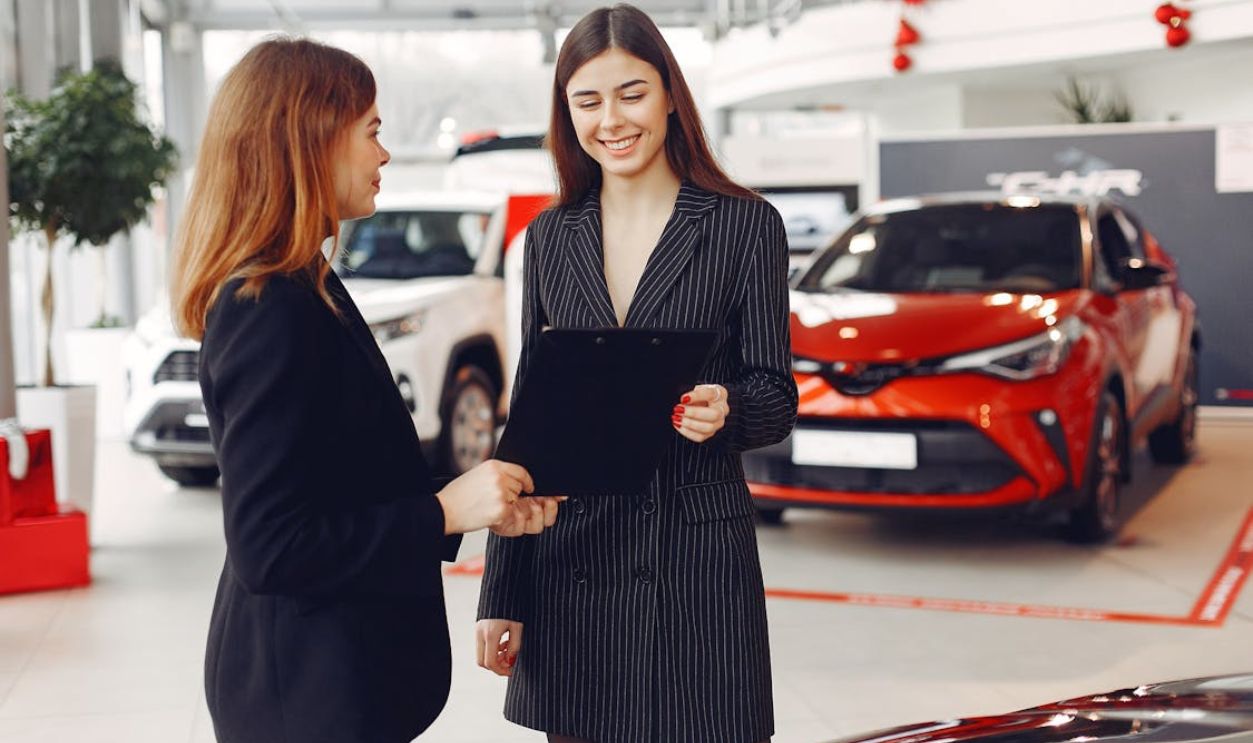 Female Car Dealer Holding a Contract