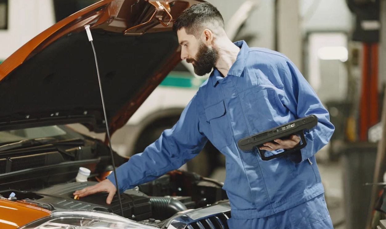 Mechanic Checking the Engine of a Car