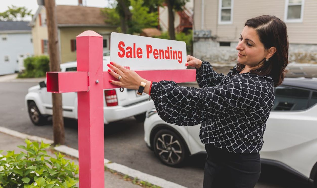 A Woman Holding a Text Signage