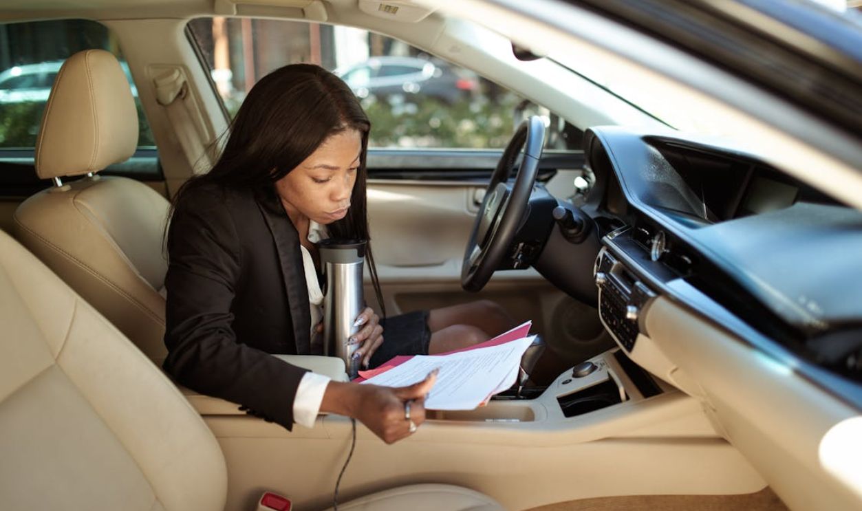 Woman Reading Documents while in Her Car