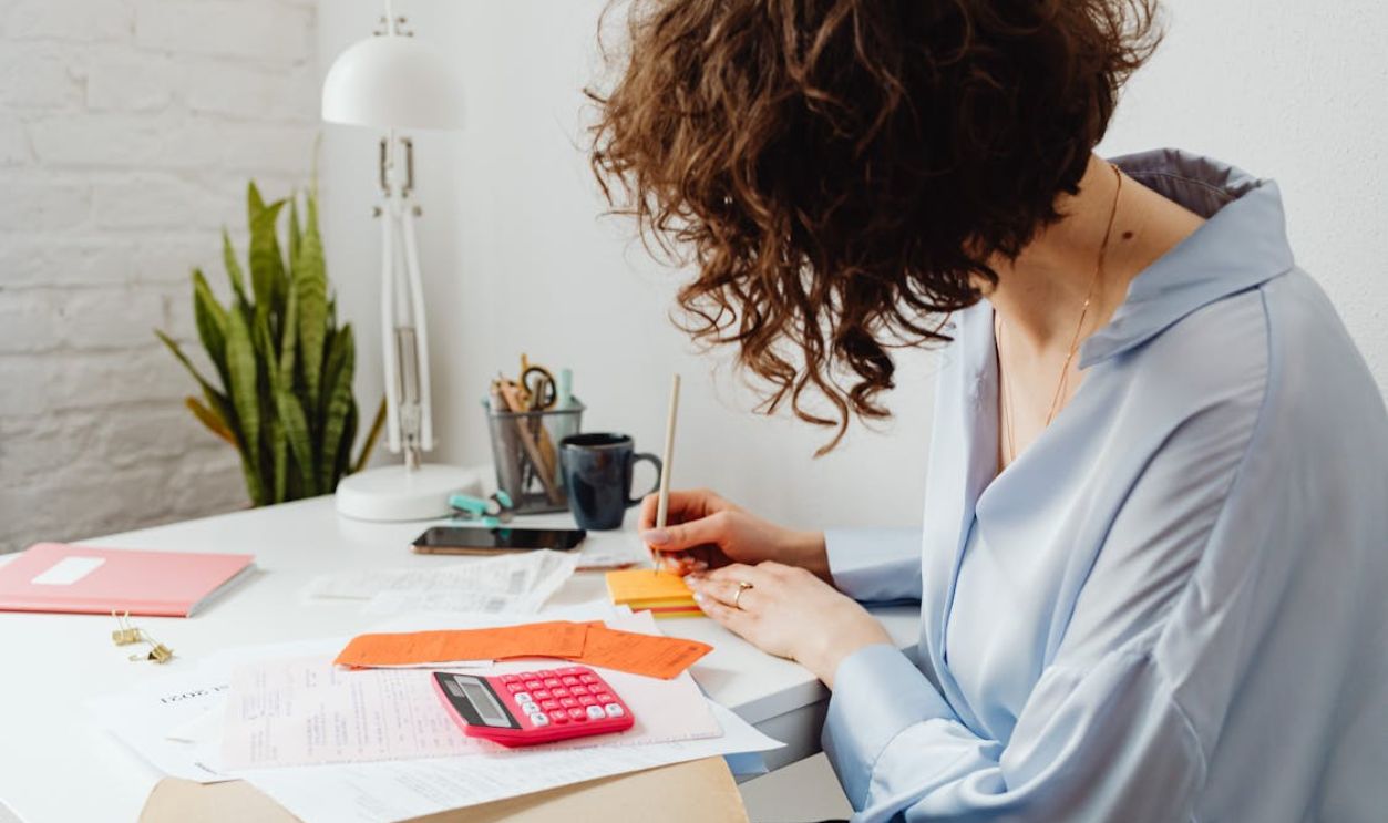 A Woman Writing on a Sticky Note