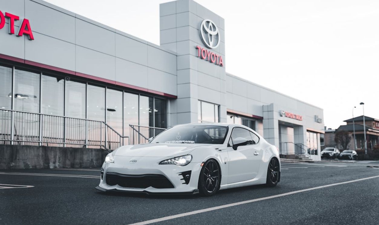 Sleek White Toyota Sports Car in Front of Dealership