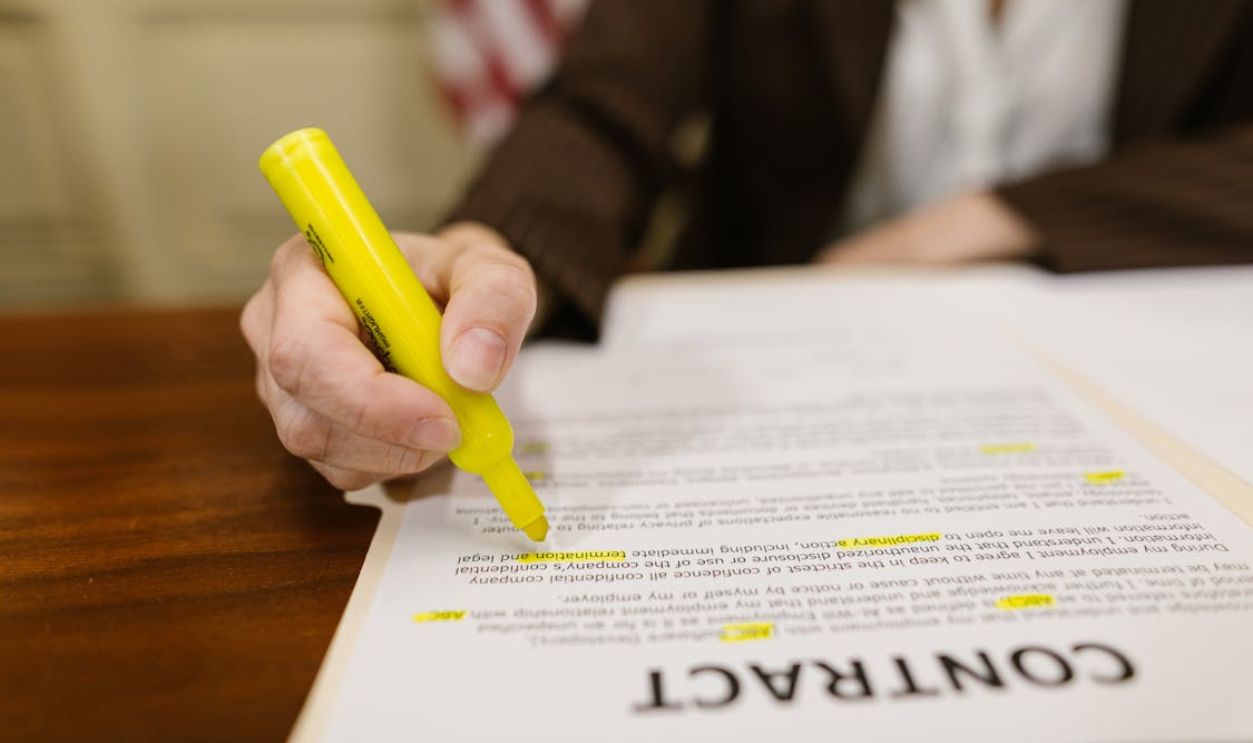 Close-Up Shot of a Person Writing on a Contract