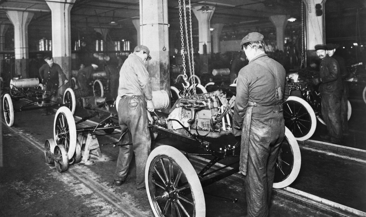 Model T Being Assembled in Ford Plant (Original Caption) An assembly line in Ford factory. Dropping the Ford engine into the Model T. Chassis-Highland Park C. Michigan.