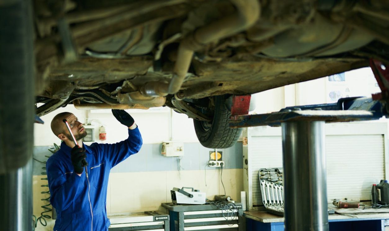 Man Under the Car Fixing the Engine