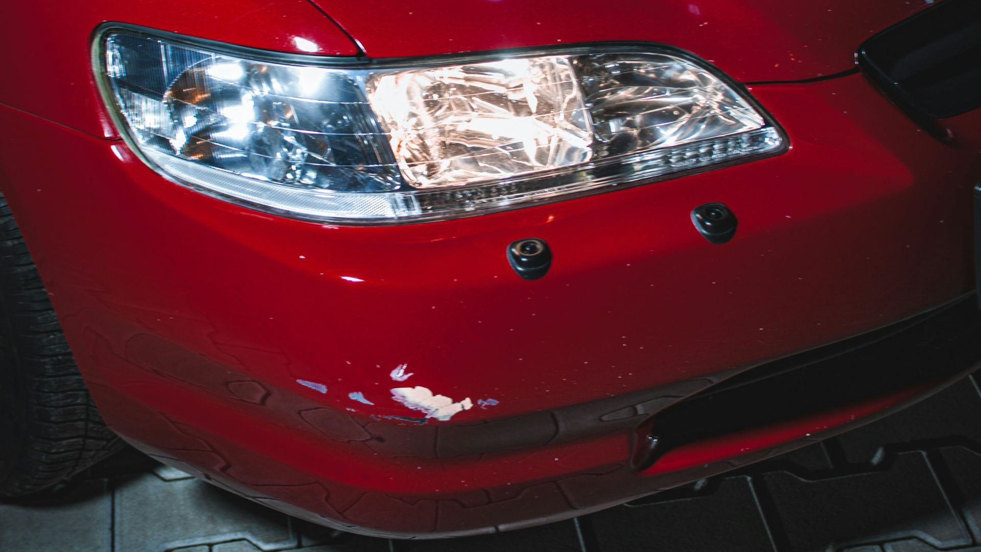 a close up of a red car on a tile floor