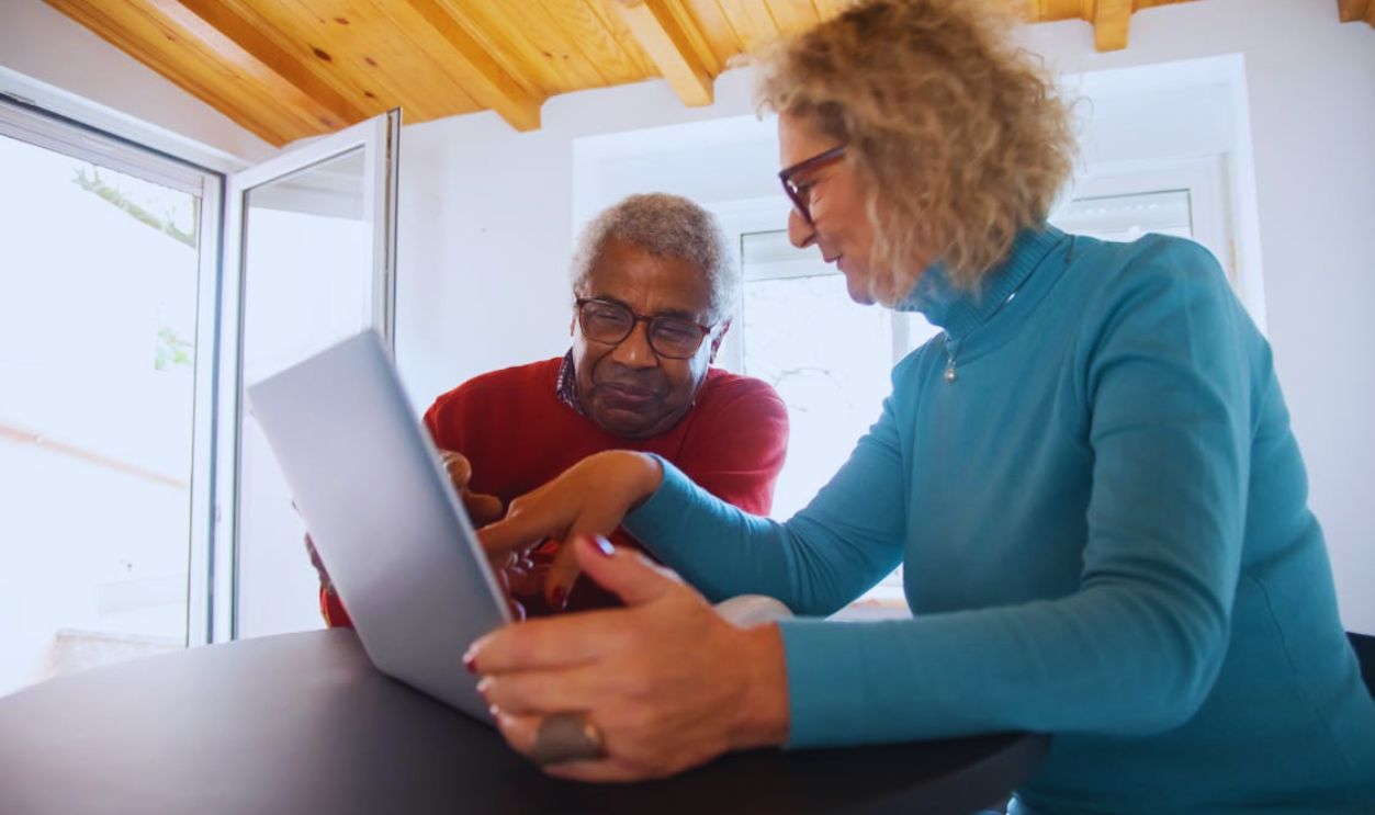 Man and Woman Wearing Sweaters Using Laptop