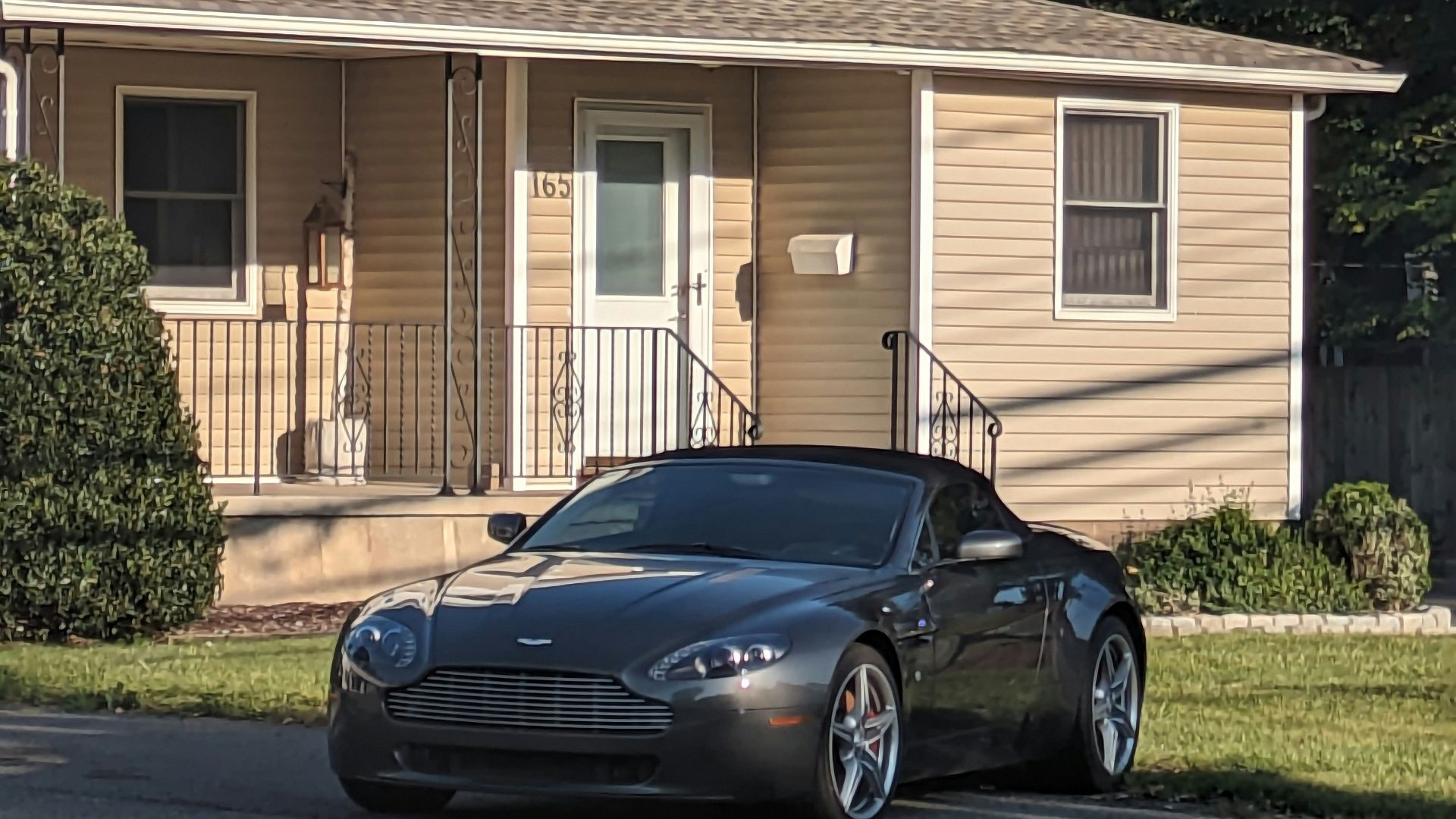 a black sports car parked in front of a house