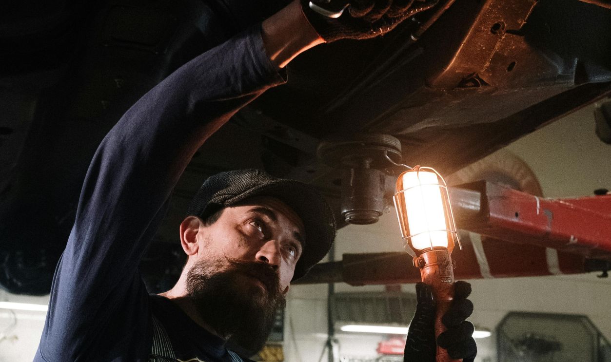 Man in Blue and White Plaid Dress Shirt Holding Red Light