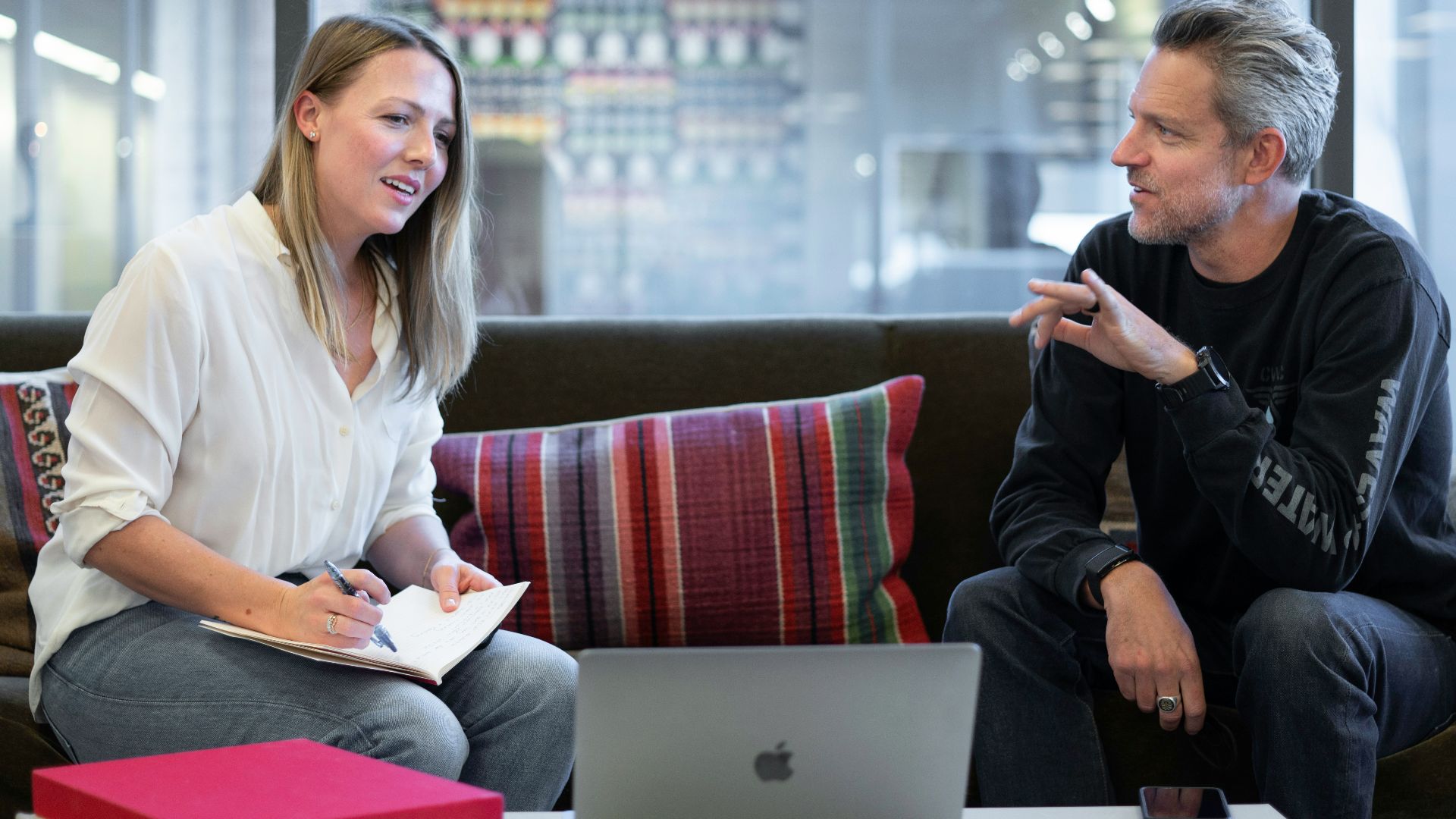 woman in white long sleeve shirt sitting on red couch