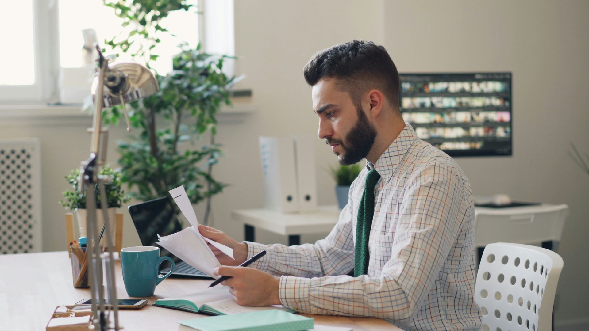 a man sitting at a desk with a laptop and papers