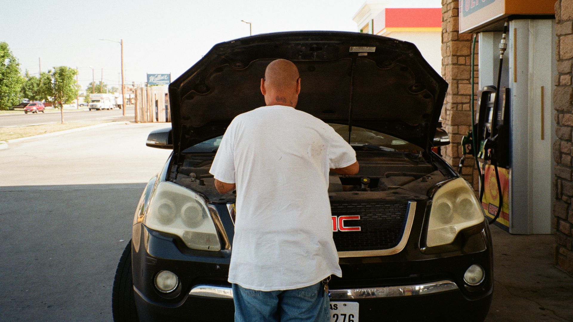 A man standing next to a car with its hood open