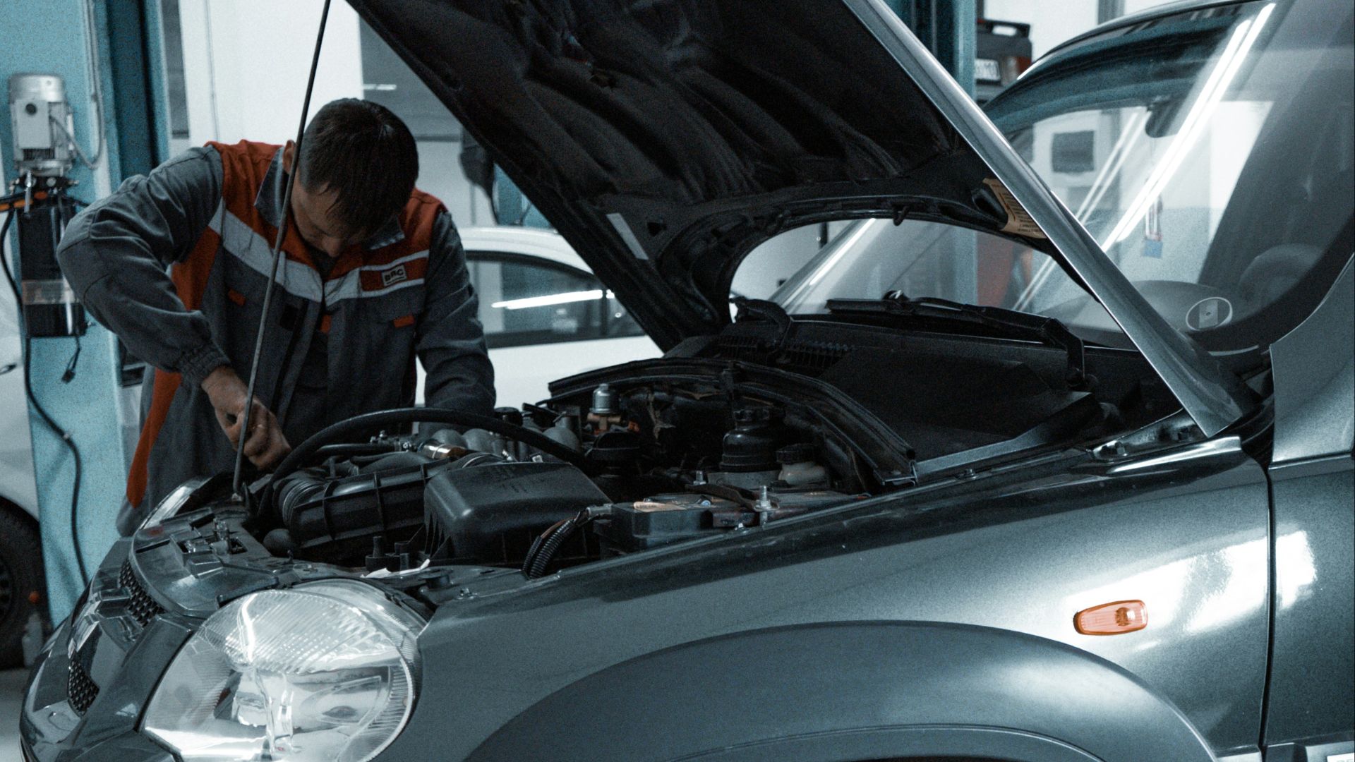 man in black jacket standing beside black car