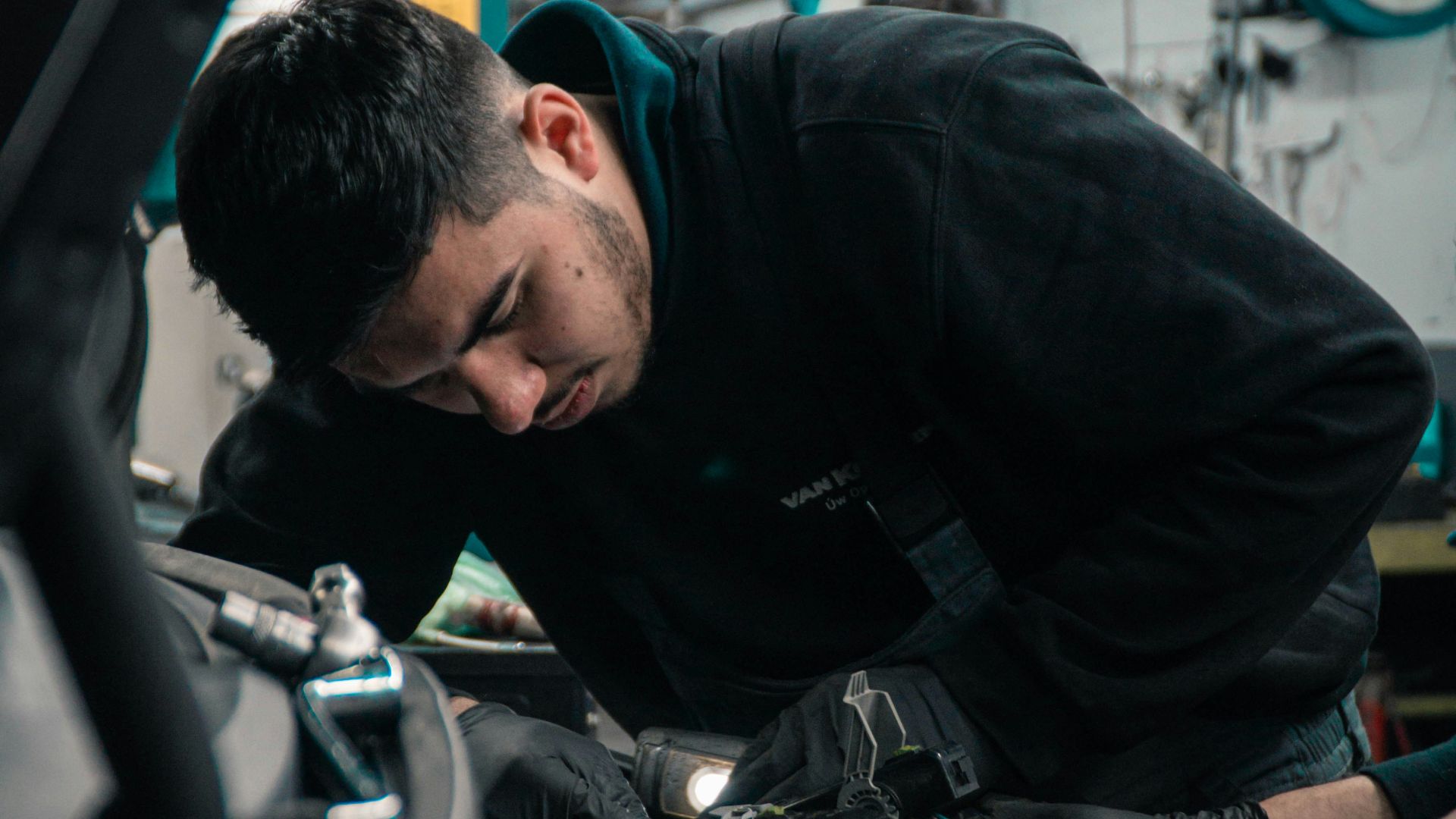man in black jacket and blue denim jeans riding motorcycle