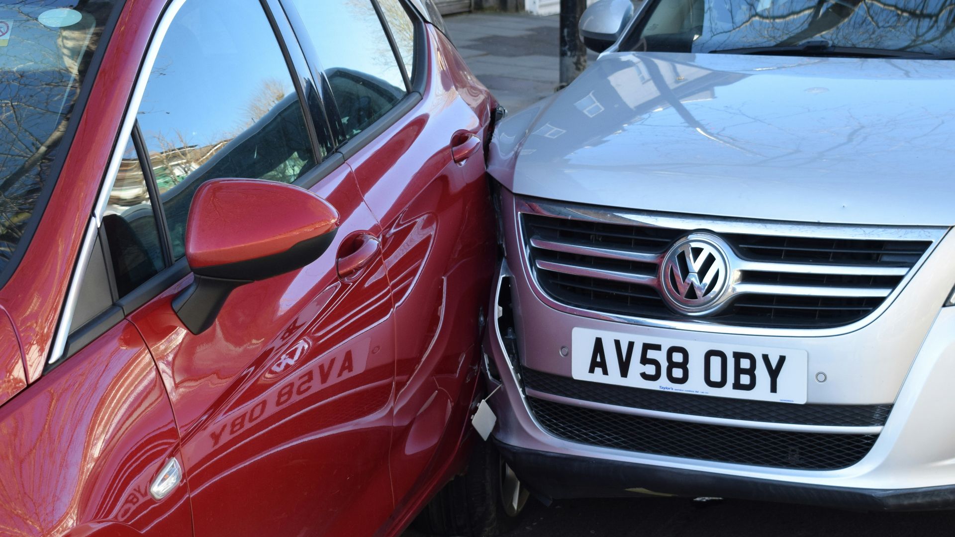two cars parked next to each other in a parking lot