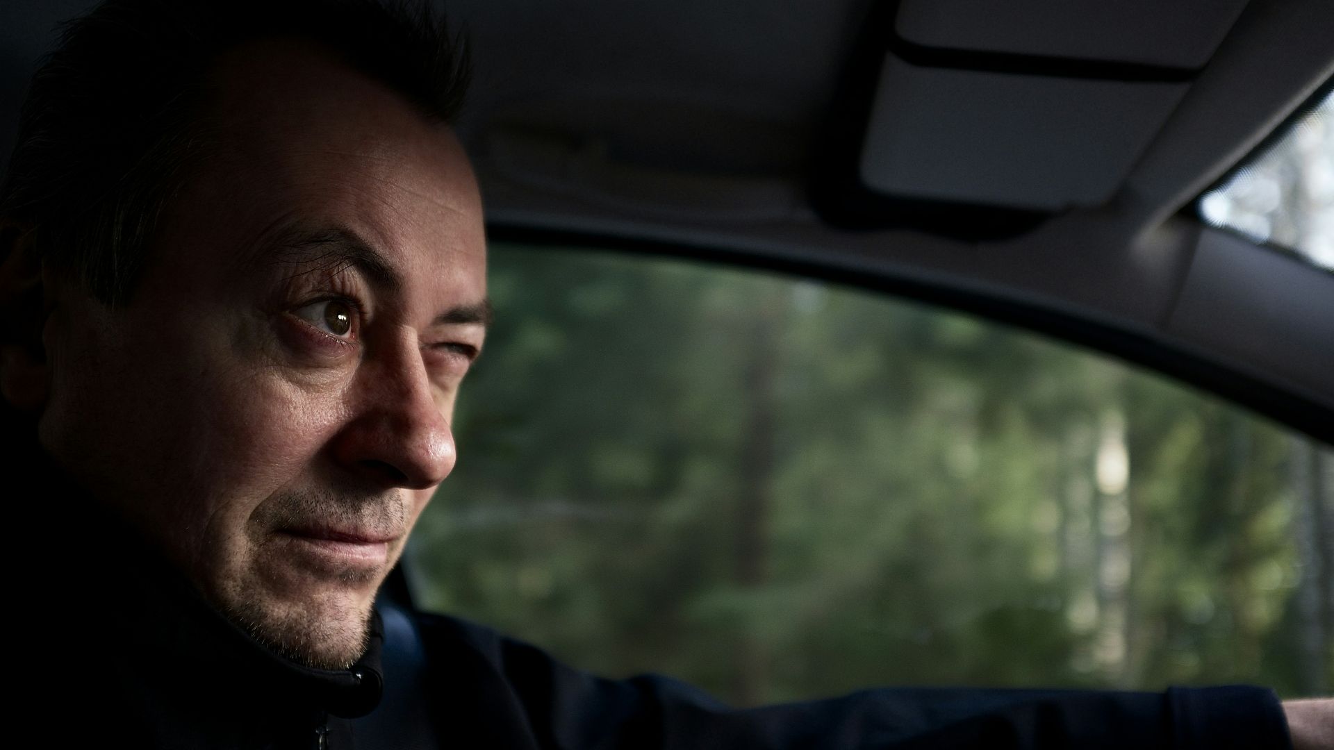 man in blue hoodie inside car