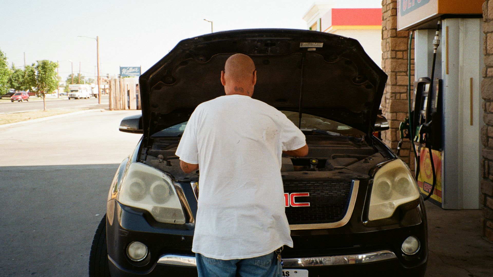 A man standing next to a car with its hood open
