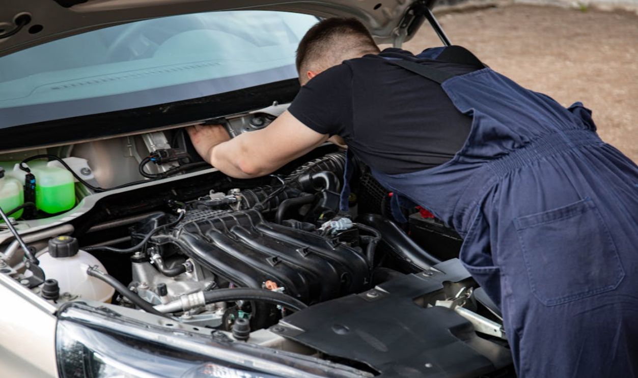 Man in Black Crew Neck T Shirt Fixing a Car