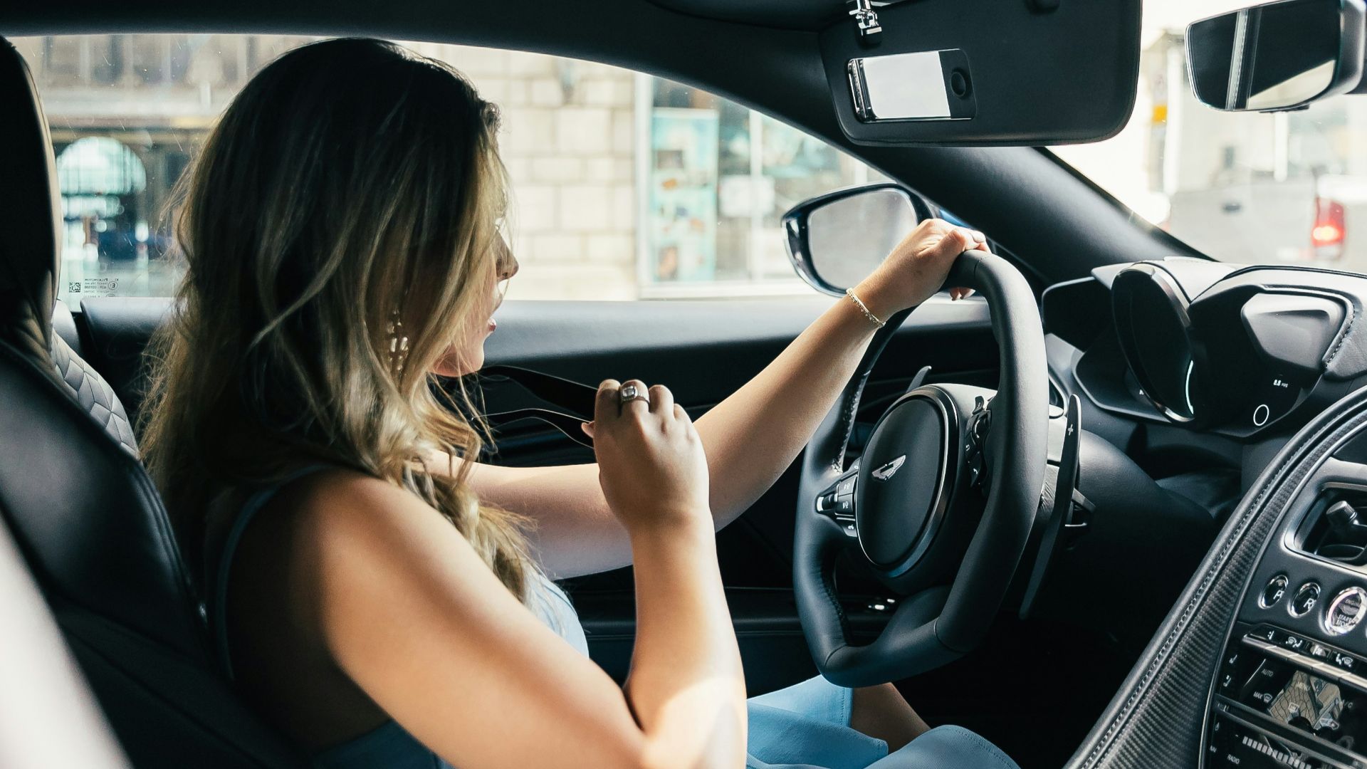 woman wearing white tank top driving vehicle during daytime