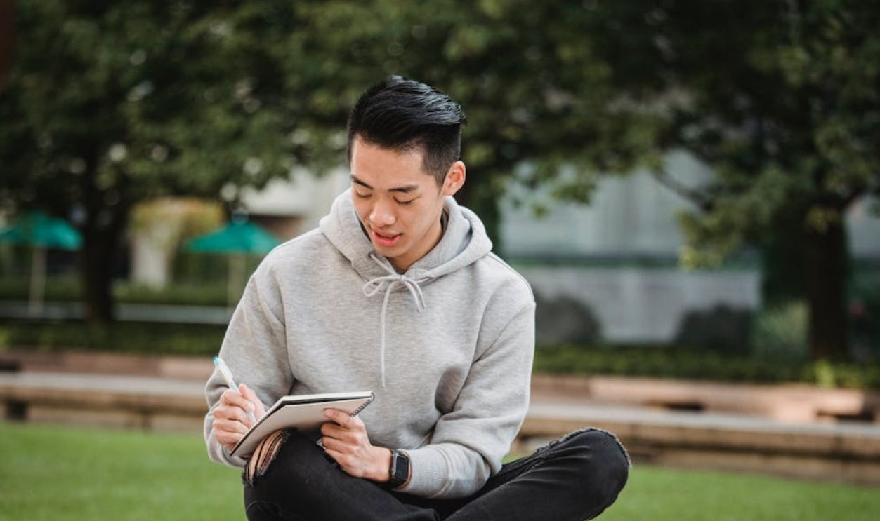 Focused ethnic man with notebook and pen